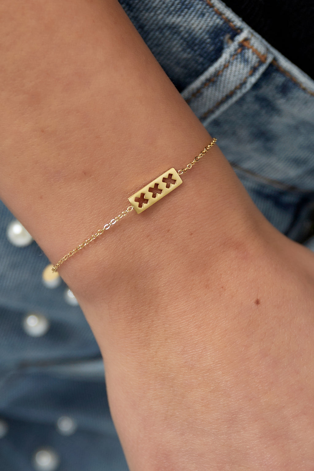 trio x armband - goud - gedragen om de arm van een model