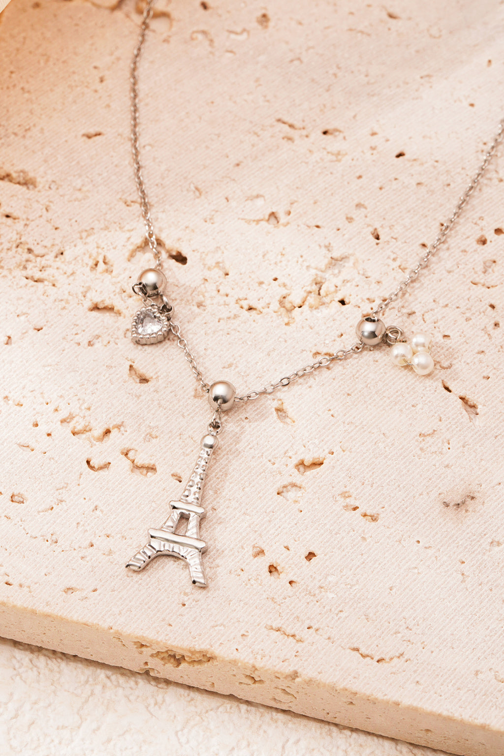 Eiffeltoren ketting - zilver - neergelegd op een stenen plaat