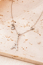 Eiffeltoren ketting - zilver - neergelegd op een stenen plaat