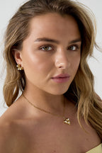 Ketting met hangend hartje en parels - gedragen om de hals van een model