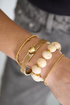 Elastieke kralenarmband met grote kralen - wit - gedragen om de arm van een model