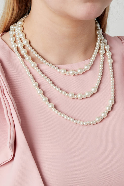 Kleine parels gelaagde ketting - gedragen om de hals van een model
