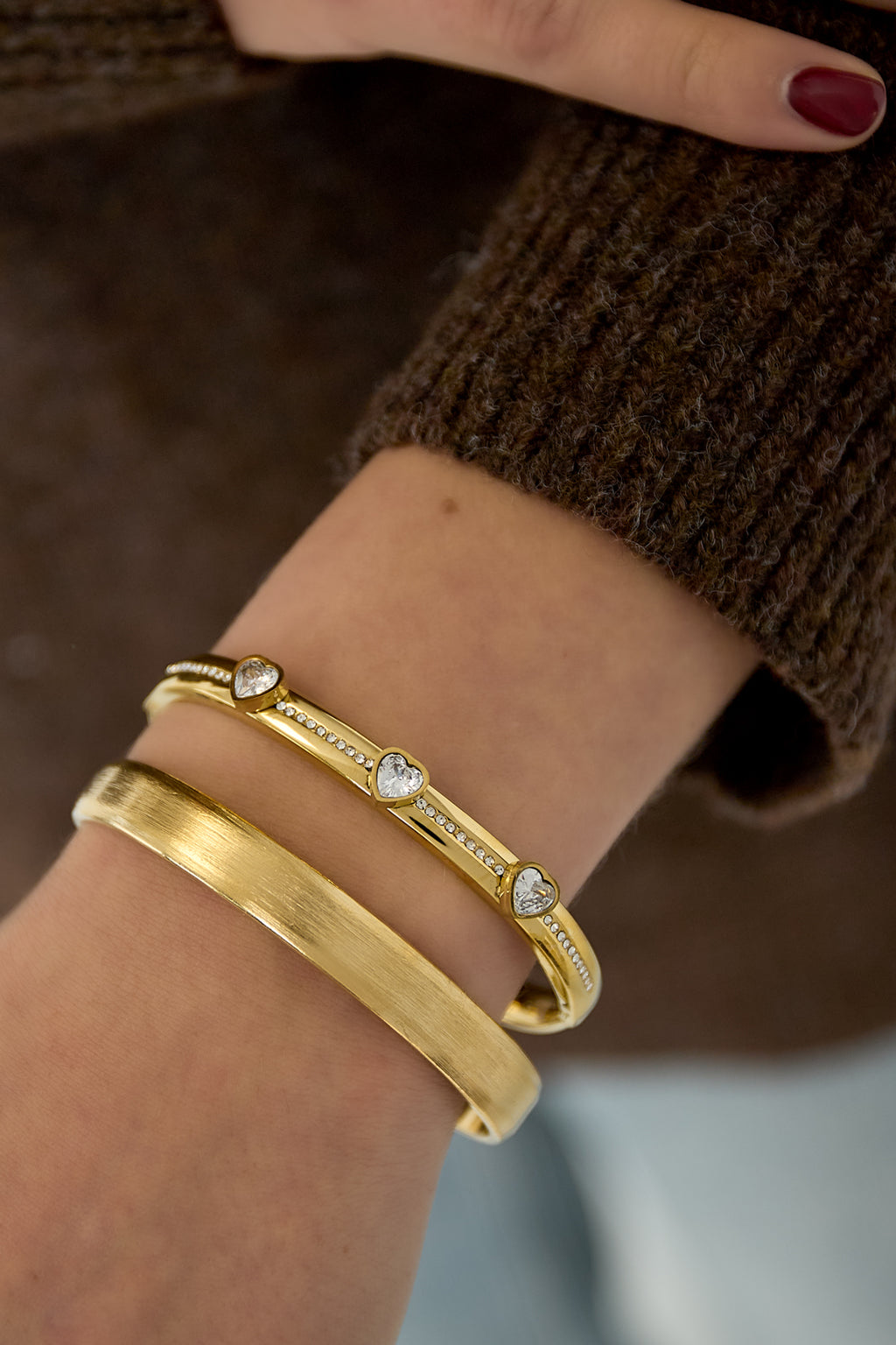 Armbanden van roestvrij staal met hart, goud - gedragen om de arm van een model